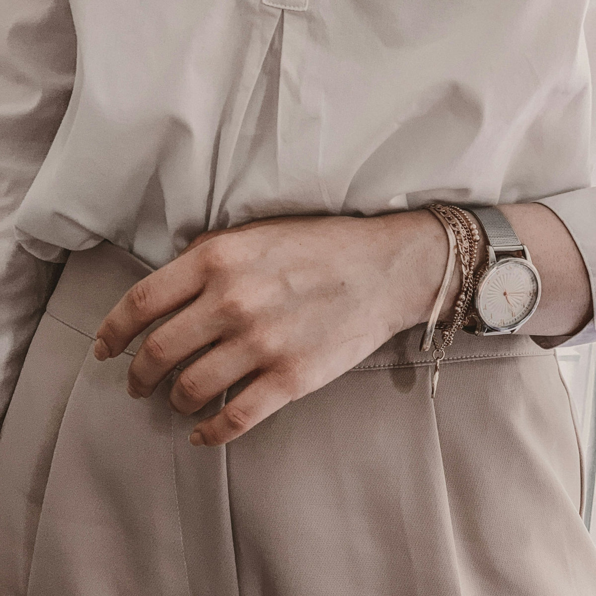 Close-up of a silver bracelet watch worn with a white shirt, illustrating watch fit on the wrist
